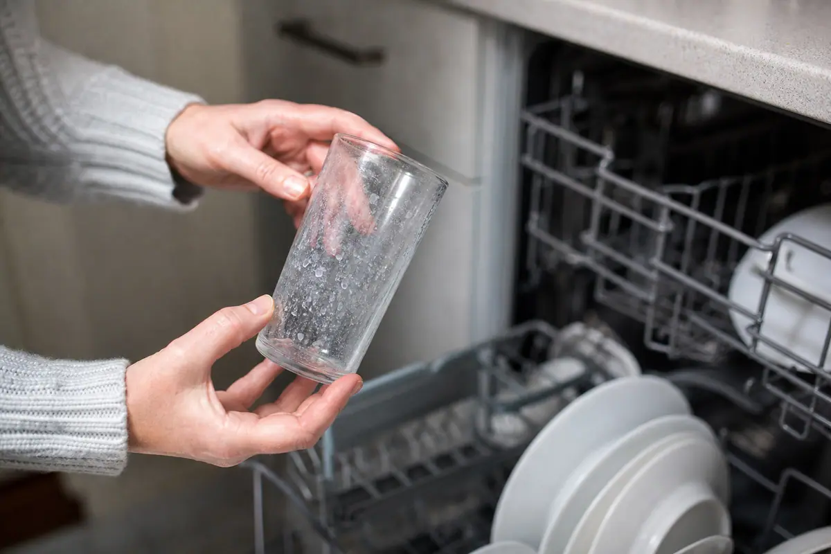 Verres à eau posés sur un plan de travail, voilés d'un film blanc de calcaire