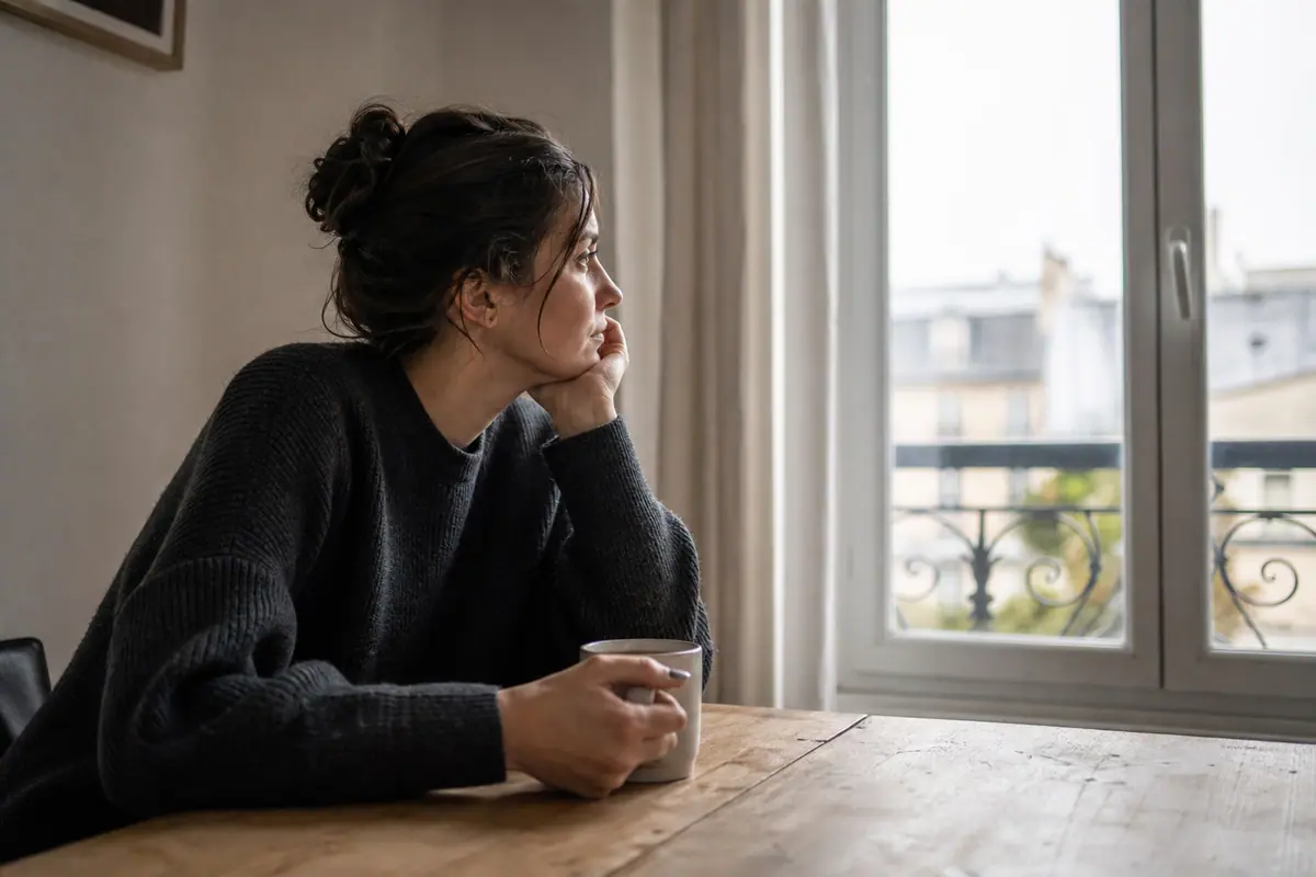 Personne regardant son téléphone avec une expression pensive, écran de messagerie affiché