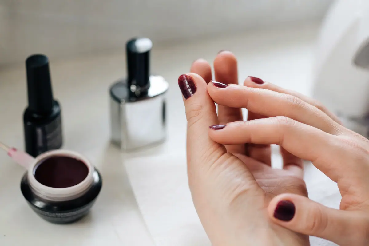 Main avec un vernis semi-permanent présentant de petites bulles sur un ongle