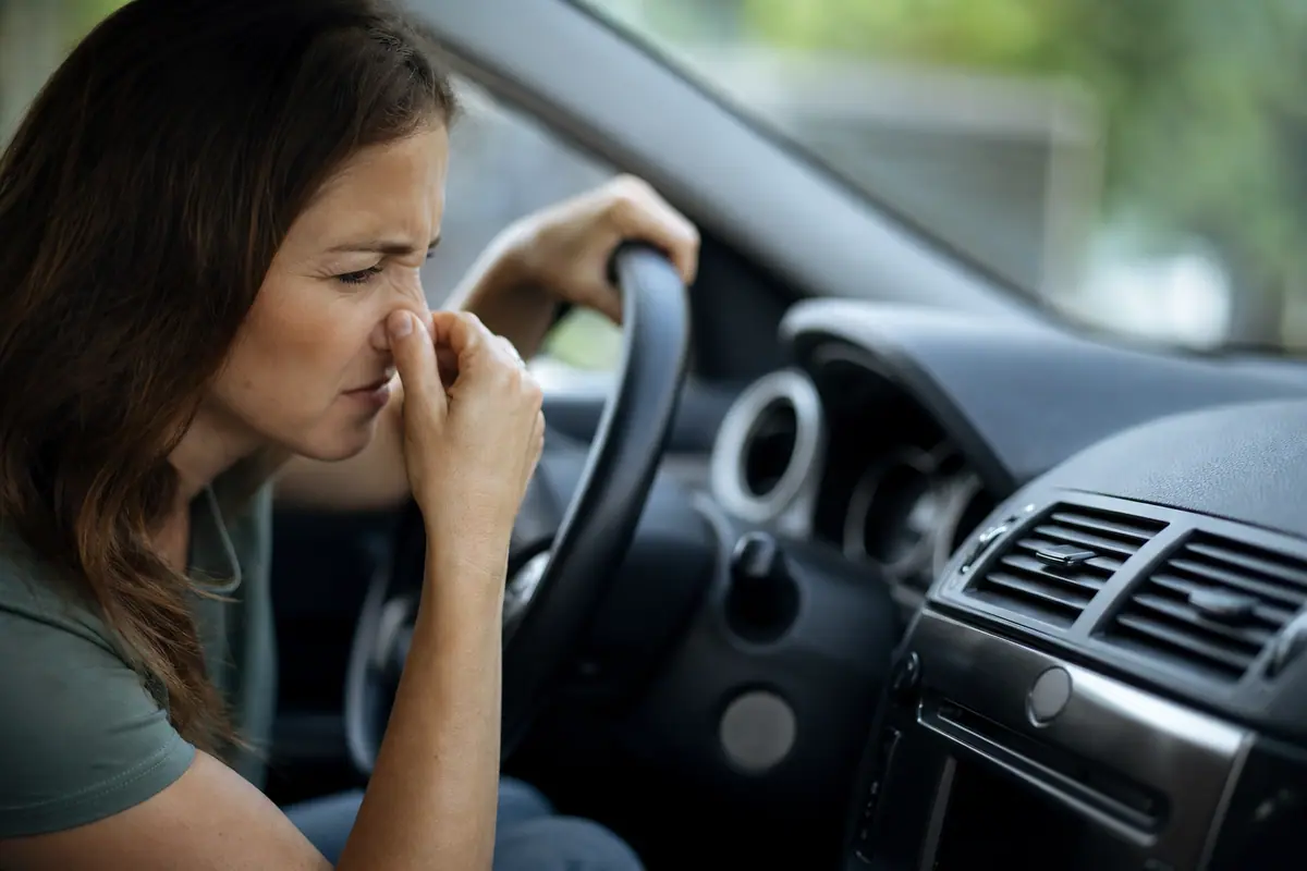 Conducteur ajustant les bouches d'aération de la climatisation au démarrage de sa voiture