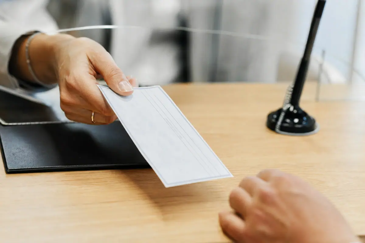 Chèque de banque posé sur un bureau à côté d'un stylo et d'un dossier