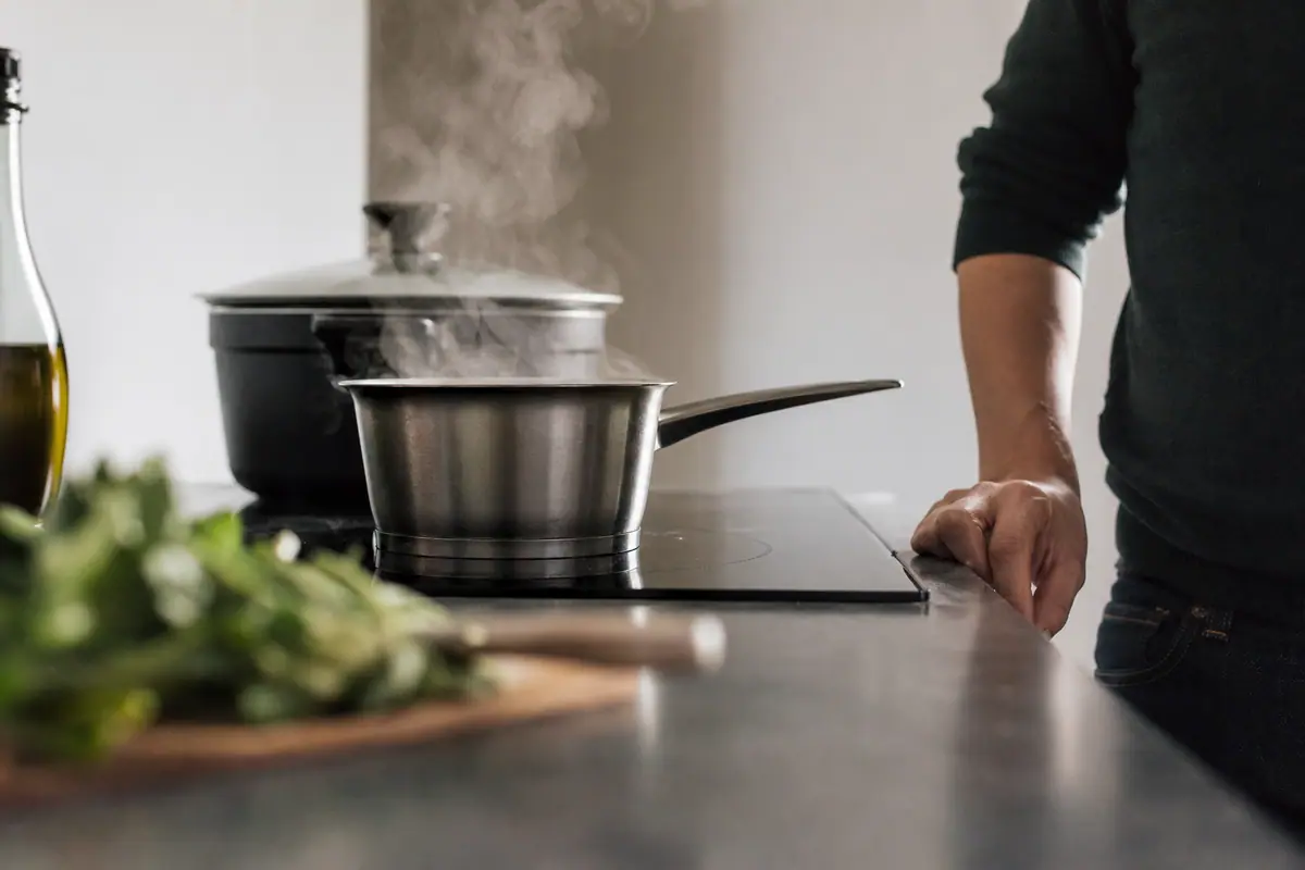 Casserole sur une plaque à induction allumée dans une cuisine moderne