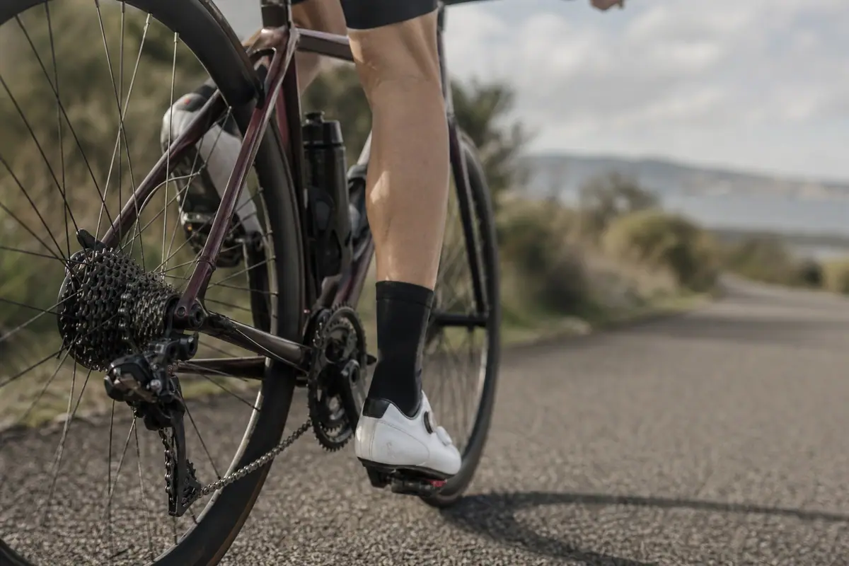 Cycliste sur une route de bord de mer, gros plan sur la cassette et le dérailleur arrière du vélo